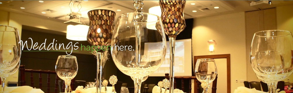 Wedding reception setup with decorated tables and glass centerpieces